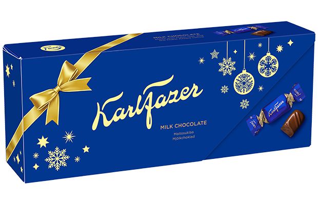 Eine festliche blaue Schachtel Fazer Milk Chocolate Praline Xmas Edition, verziert mit gelben Akzenten, Schneeflocken, einer großen Schleife und goldener Schrift; rechts die ausgepackten und eingepackten Pralinen - ein ideales finnisches Weihnachtsgeschenk von Fazer.