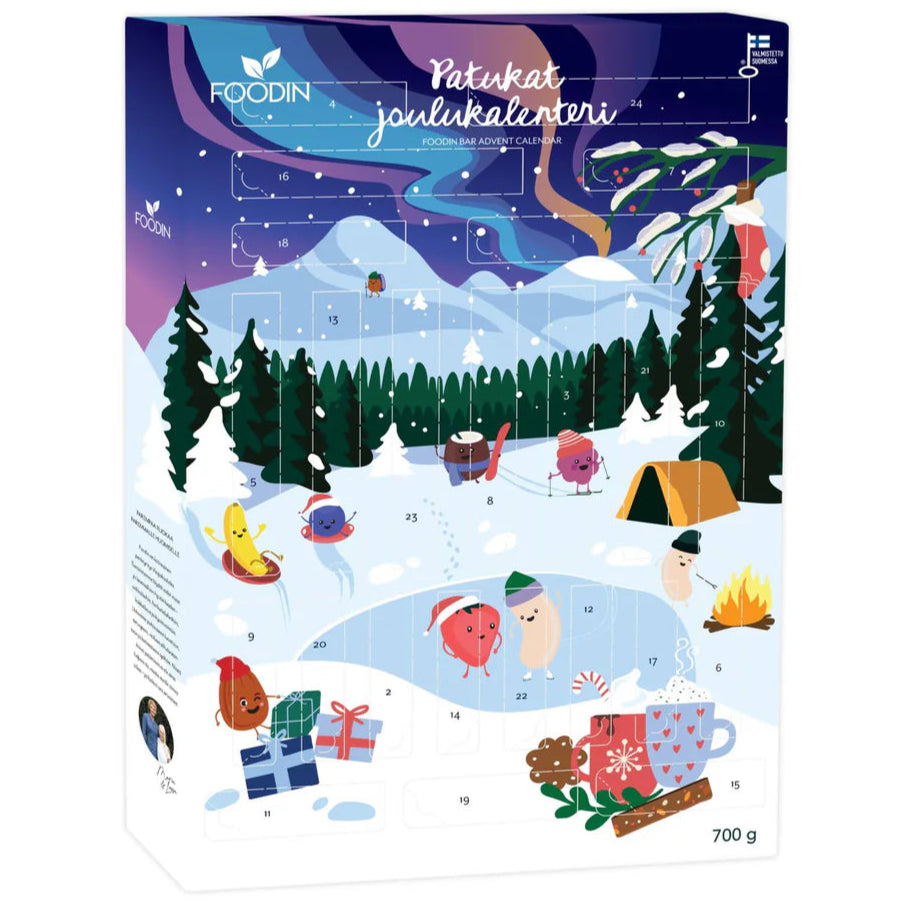 The Foodin Bar Advent Calendar by Foodin features a snowy winter scene with cartoon animals sledding, skiing, and skateboarding among trees, gifts, a campfire, and a tent. Each window reveals healthy snack bars made with natural ingredients. Text in Finnish.