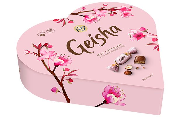 The Fazer Geisha Gift Box is a heart-shaped pink box of Finnish chocolate, decorated with cherry blossom art, the Geisha logo, and images of milk chocolate with hazelnut filling by Fazer.
