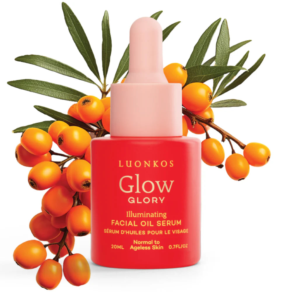 A pink dropper bottle of Luonkos Glory Facial Oil Serum from Luonkos is shown in front of a sea buckthorn branch with orange berries and green leaves, emphasizing its nourishing formula for deep hydration.