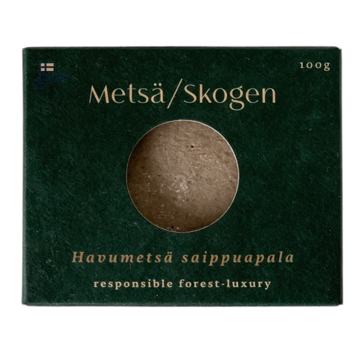 A dark green Metsä/Skogen box with a round window reveals the brown Pine Forest Salt Soap inside. Below, it reads: "Handcrafted in Finland forest-luxury salt soap." 100g.