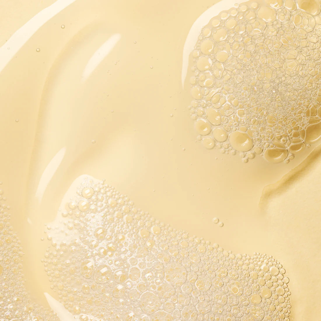 Nahaufnahme des klaren, blassgelben Lumene Nordic-C Strength & Shine Shampoo mit kleinen, glänzenden Bläschen, die der Flüssigkeit ein strukturiertes und glänzendes Aussehen verleihen.