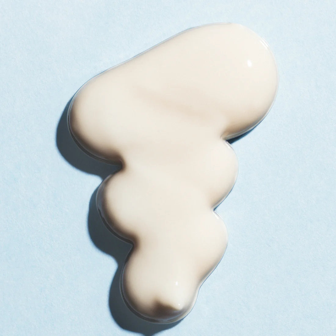 Ein Klecks Lumene Nordic Hydra Fresh Hydration Moisturizer SPF50, eine cremefarbene Creme von Lumene, ist in unregelmäßiger Form auf einem hellblauen Hintergrund verteilt.