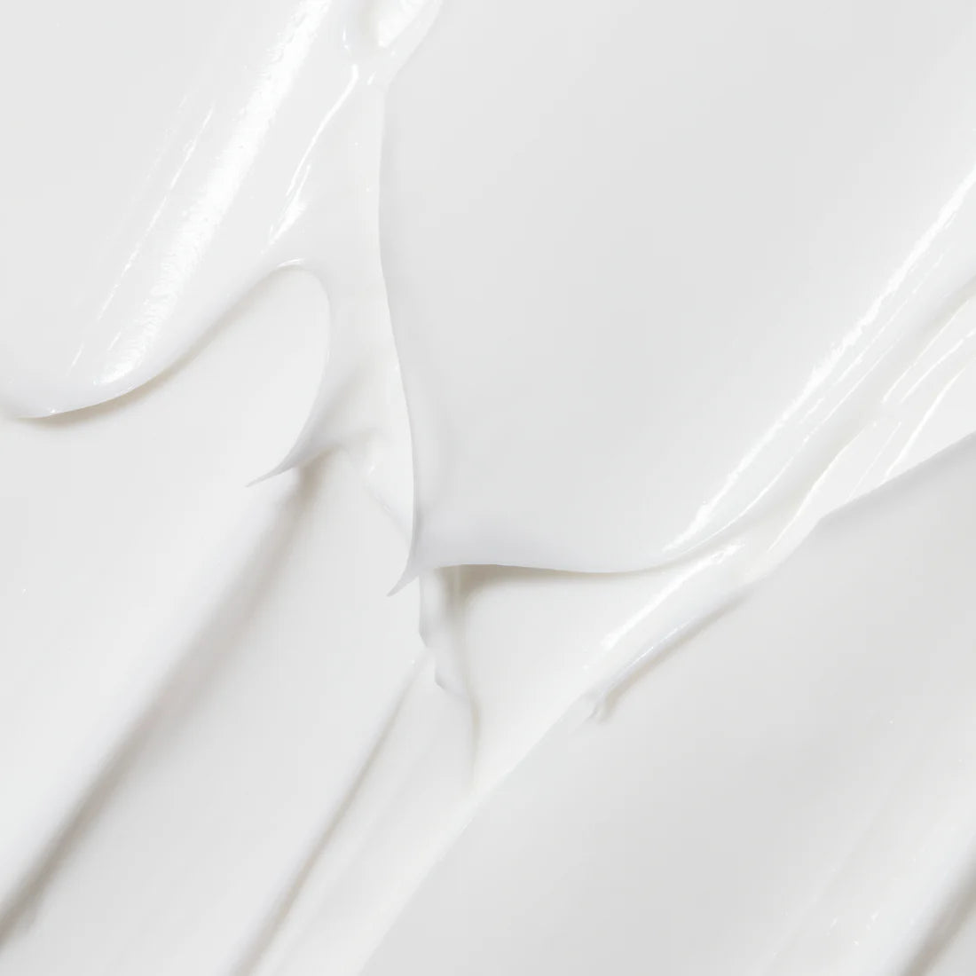 Eine Nahaufnahme des Lumene Nordic Hydra Moisture Balm von Lumene, einer glatten, weißen Creme mit dreifacher Hyaluronsäure, die in sanften Wellen verteilt wird, um ihre feuchtigkeitsspendende Wirkung zu unterstreichen.