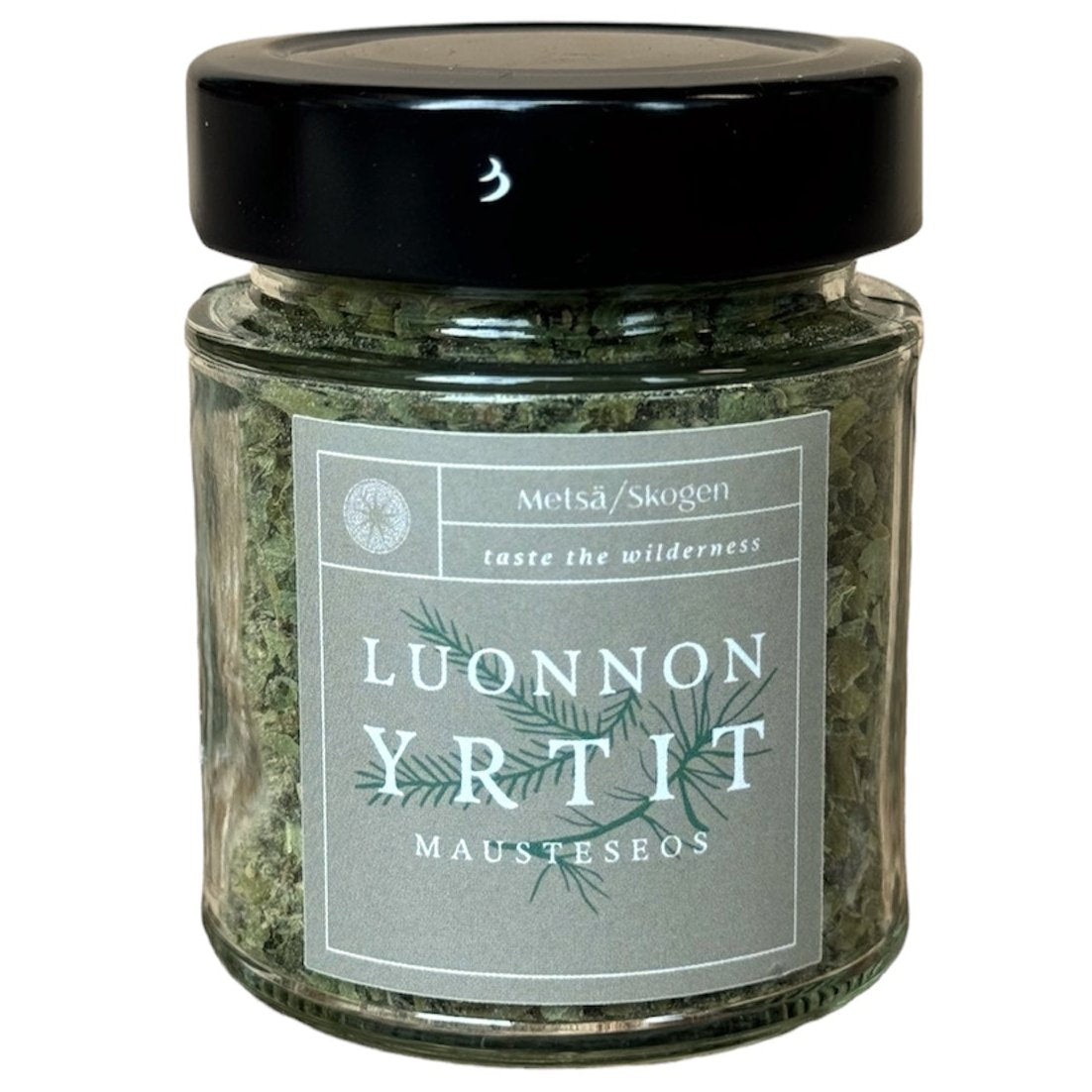 Die Metsä/Skogen Naturkräutermischung wird in einem Glasgefäß mit schwarzem Deckel geliefert, auf dem ein einfaches Blattetikett mit der Aufschrift "Metsä/Skogen, taste the wilderness" und "Luonnon Yrtit Mausteseos" angebracht ist. Handgefertigt in Finnland.