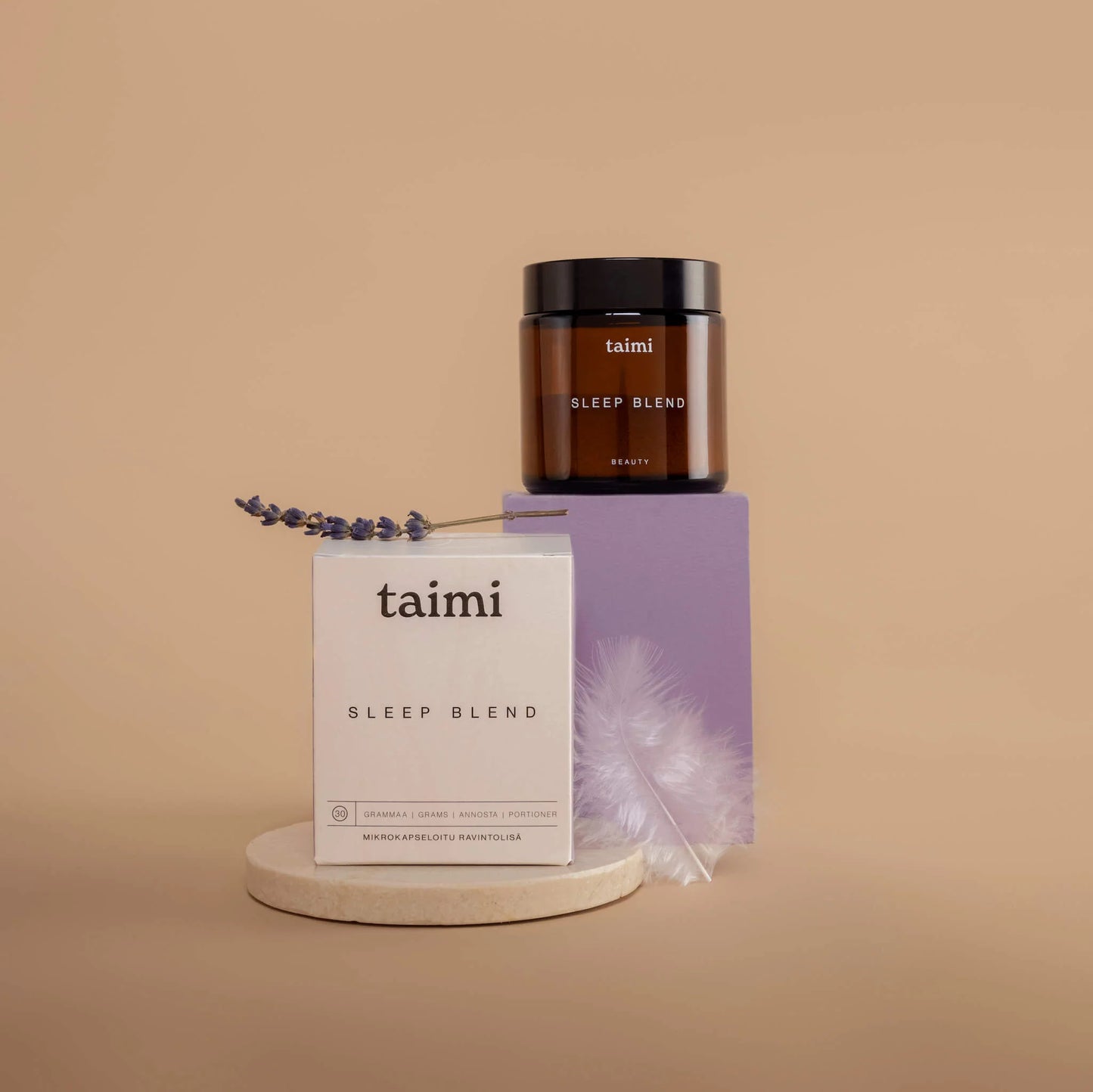 Ein Tiegel und eine Dose der Taimi Sleep Blend von Taimi, die mit Magnesium für Entspannung sorgt, stehen auf einem minimalistischen Ständer neben Lavendel und einer weißen Feder vor einem beigen Hintergrund.