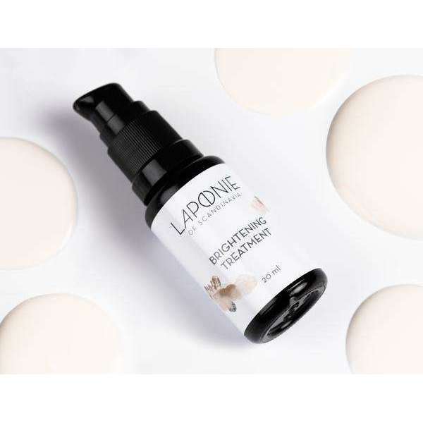 Eine Flasche Laponie of Scandinavia Clarifying Treatment Serum für empfindliche Haut ruht auf einer weißen Oberfläche mit cremigen Lotionflecken. Der Flakon hat eine schwarze Pumpe und ein weißes Etikett mit schwarzem Text und dezenten floralen Akzenten.