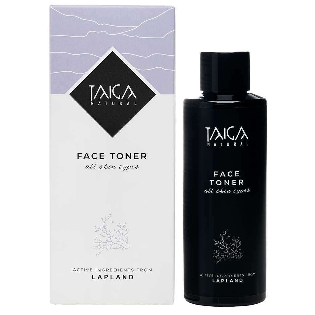 Die schwarze Flasche von Taiga Cosmetics Face Toner All Skin Types steht neben der weißen und lavendelfarbenen Schachtel, die beide die Marke Taiga Cosmetics präsentieren und natürliche lappländische Inhaltsstoffe für die sanfte Reinigung aller Hauttypen enthalten.