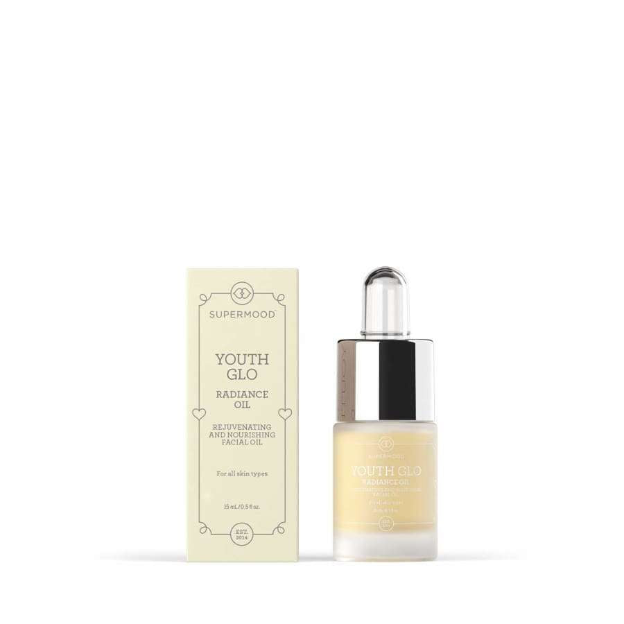 Eine Flasche Supermood Youth Glo The Radiance Oil mit Tropfverschluss ist neben der cremefarbenen Schachtel abgebildet. Auf beiden sind die Marke Supermood und der Produktname in eleganten Schrifttypen abgebildet, die die Anti-Aging-Formel hervorheben.