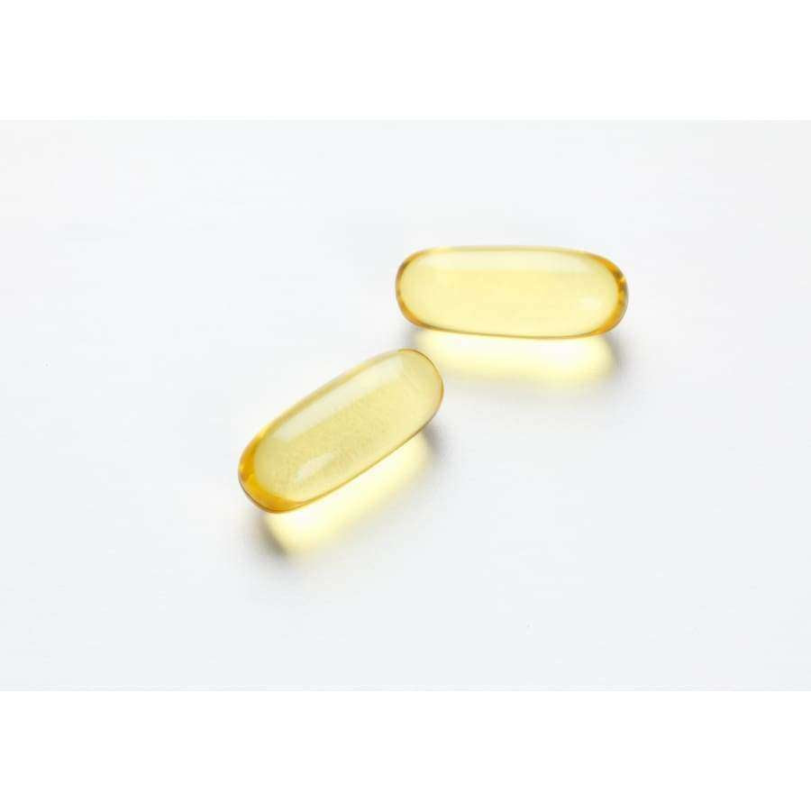 Deux capsules gelatineuses Möller Double Omega-3 de couleur jaune translucide, riches en acides gras oméga-3, reposent sur une surface blanche, légèrement espacées l'une de l'autre et projetant de légères ombres.