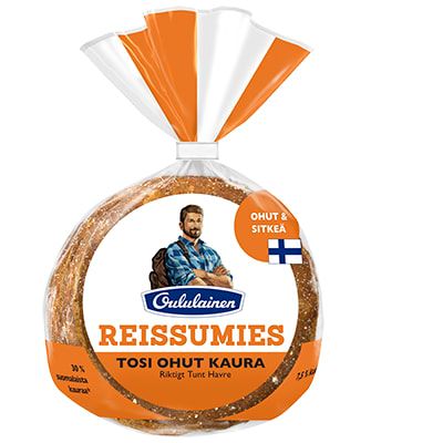 Confezione di pane d'avena Oululainen Reissumies Really Thin Oat bread di Oululainen, con l'immagine di un escursionista e la bandiera finlandese sulla parte anteriore. Il pane d'avena vegano, di forma rotonda, è visibile attraverso la confezione trasparente.