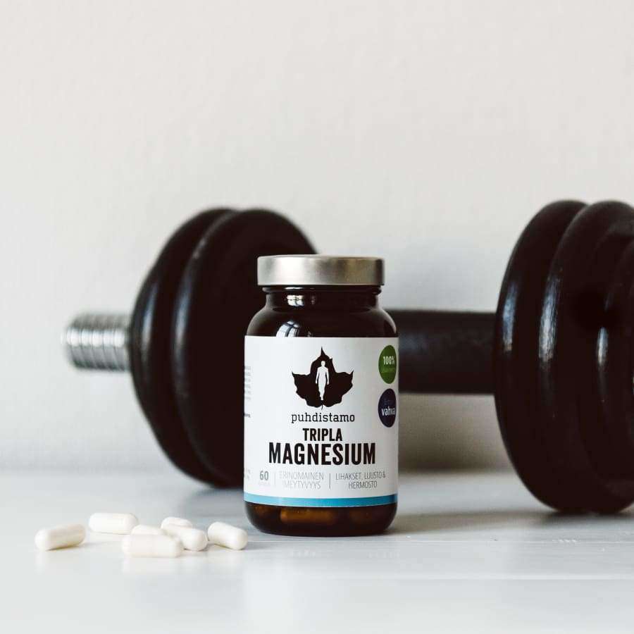 Un barattolo di Puhdistamo Triple Magnesium di Puhdistamo è appoggiato su una superficie bianca accanto a un manubrio nero, con diverse capsule bianche sparse lì vicino.
