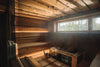 Warm wooden interior of a traditional Finnish sauna with stove stones, bucket and ladle