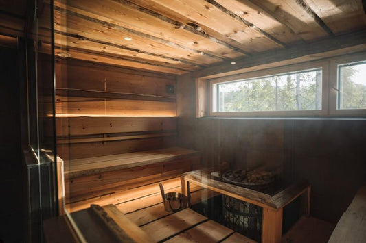 Warm wooden interior of a traditional Finnish sauna with stove stones, bucket and ladle