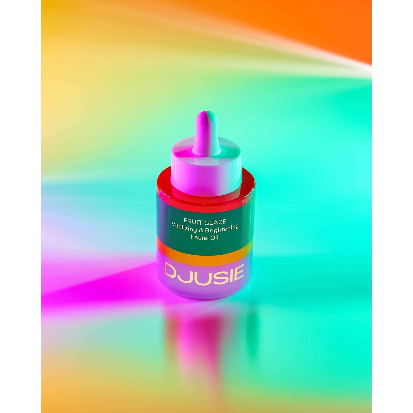 A bottle of Djusie Fruit Glaze Vitalizing & Brightening Face Oil stands on a vibrant background—ideal as a squalane face oil from Djusie for glowing skin and prevention of pigment spots.