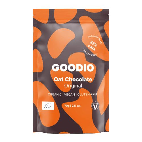 A 70g pouch of Goodio Organic Oat Chocolate Beans Original, featuring an orange and dark brown abstract pattern. This organic, vegan chocolate from Goodio is gluten-free and made with 22% gluten-free oats.