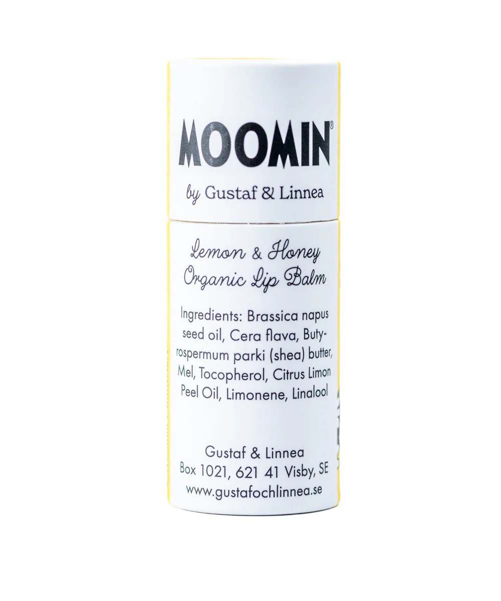 A cylindrical tube of Gustaf & Linnea Moomin Lipbalm Little My, an eco-friendly lip balm with ingredients and contact info shown on a white label with yellow accents.