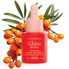 A pink dropper bottle of Luonkos Glory Facial Oil Serum from Luonkos is shown in front of a sea buckthorn branch with orange berries and green leaves, emphasizing its nourishing formula for deep hydration.