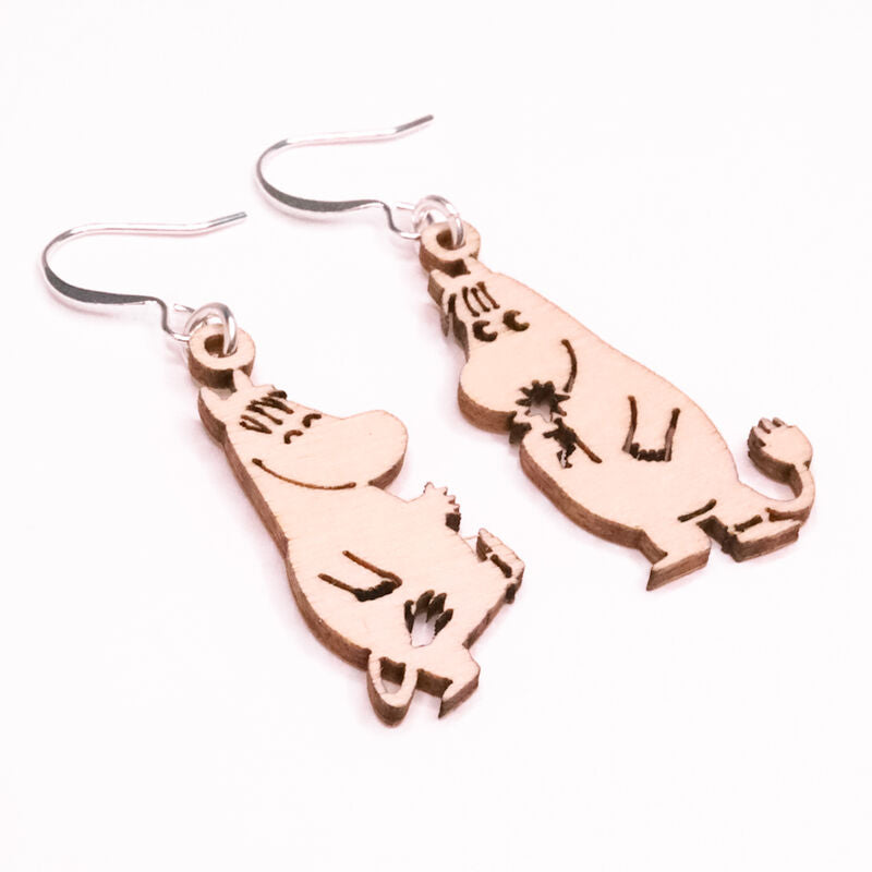 Coruu Moomin Wooden Earrings by Coruu, crafted from Finnish birch with engraved details and metal hooks, feature beloved Moomin characters. Displayed on a white background, these earrings are a charming piece of Nordic jewelry.