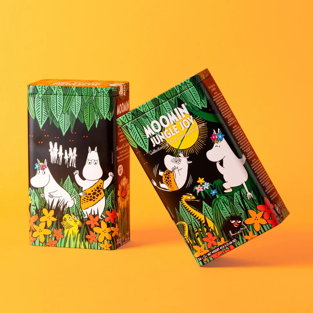 Two Moomba-style snack boxes with tropical jungle artwork, shown on a solid orange background. One box stands upright and the other leans diagonally beside it, both featuring illustrated characters, flowers, leaves, and the text 'MOONIN' JUNGLE JOY'.