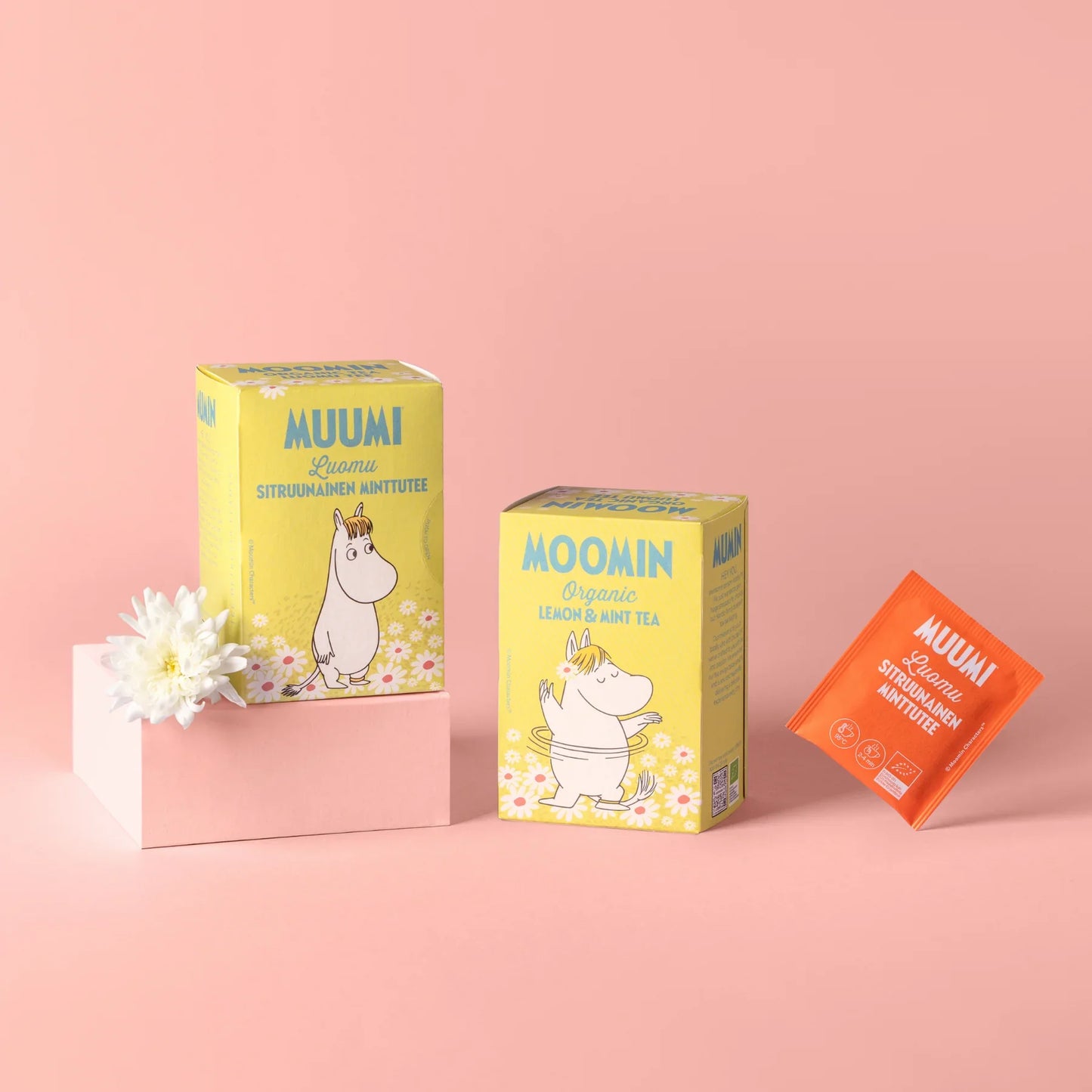Three Moomin-themed tea boxes on a pink background