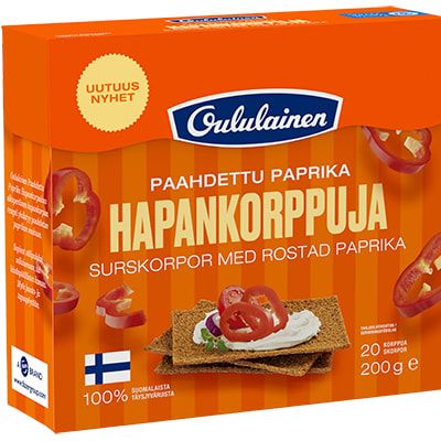 A box of Oululainen Rye Crisp Bread Roasted Pepper, a healthy Finnish snack. The orange package shows crispbread slices with cream cheese and paprika, plus images of vibrant red peppers. Brand: Oululainen.