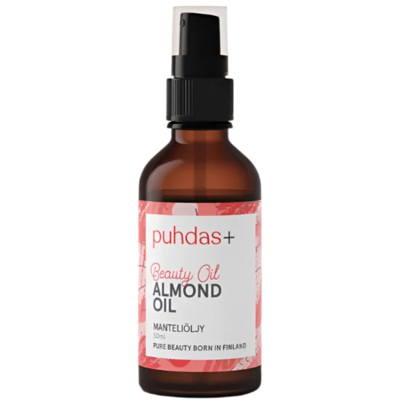 A bottle of puhdas+ Beauty Oil Almond Oil, featuring an amber glass bottle with a black spray pump and a white label with pink accents, set against a plain white background.