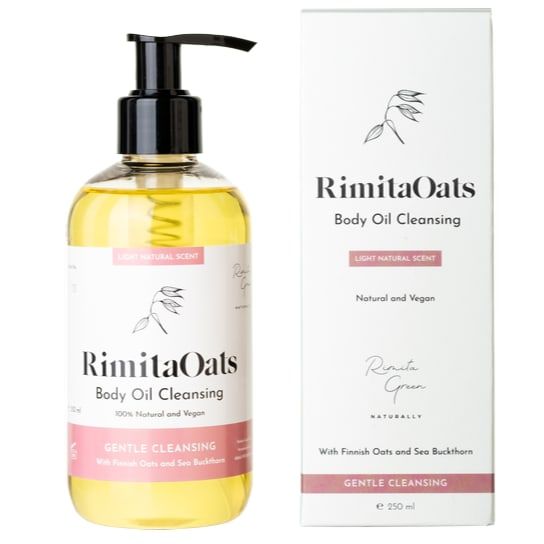 A bottle of Rimita Green’s RimitaOats Body Oil Cleansing stands beside its box. The white packaging features black and pink text, highlighting Gentle Cleansing as well as its 100% natural and vegan formula.