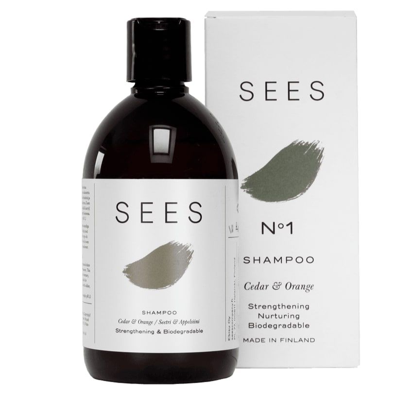 A bottle of SEES Company Shampoo No. 1 Cedar & Orange with its box. Labeled Strengthening, Nurturing, Biodegradable, this vegan Finnish haircare product features a minimalist white and green design.