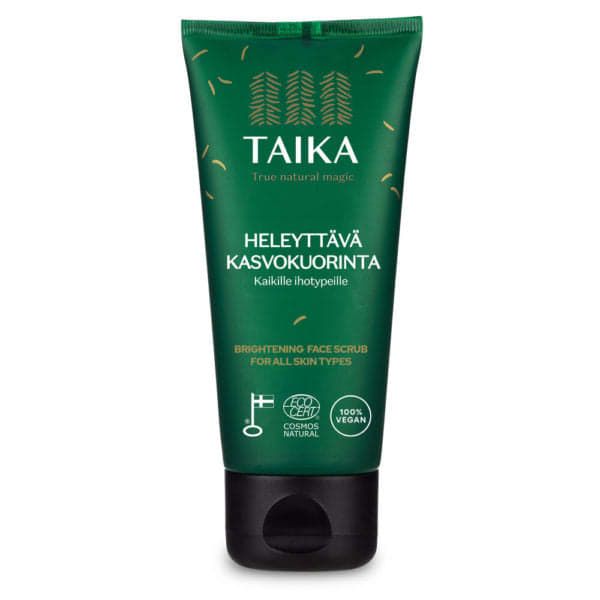 A green tube of Taika Brightening Face Scrub for all skin types, with Finnish and English text, eco-certification logos, and a black cap—moisturizing exfoliation leaves skin smooth and radiant.