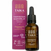A brown glass dropper bottle labeled Taika Regenerating Face Oil by Taika is displayed before a matching pink box with Finnish and English text, promoting its vegan, natural, anti-aging formula with Finnish forest microbe extract.