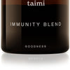 A brown glass jar with a black lid features the Taimi brand on top, "Taimi Immunity Blend" in the center, and "Goodness" at the bottom. The minimalist label highlights this vegan immune support formula made with adaptogenic herbs.