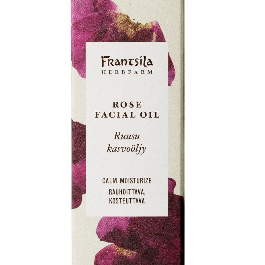 A rectangular box of Frantsila Midsummer Rose Facial Oil with purple rose artwork and bilingual text showcases this calming, moisturizing natural cosmetic, enriched with nourishing rosehip seed oil.