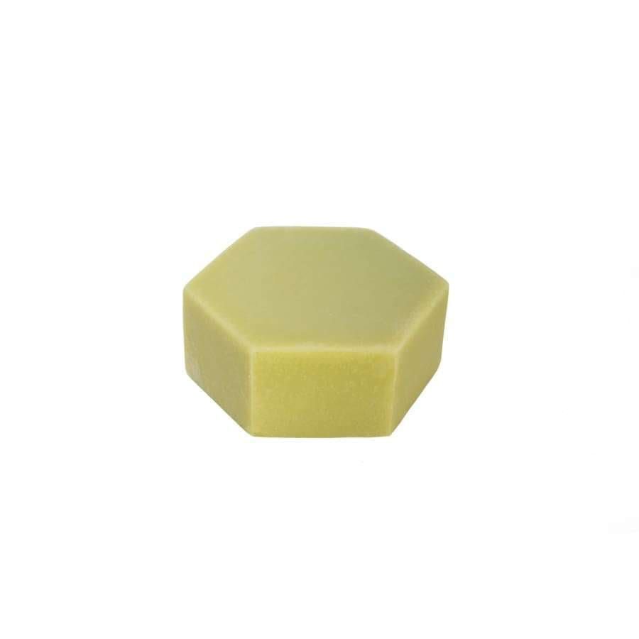 The Luonkos Healing Oil Cleansing Cake by Luonkos is a light yellow, hexagon-shaped solid bar made from natural ingredients, ideal for a refreshing skincare routine. Shown on a plain white background.