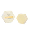 A hexagonal pale yellow Luonkos Innocent Nurturing Body Cake sits beside its matching cream box, both labeled Luonkos and made with natural ingredients for dry and sensitive skin.