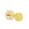 A hexagonal yellow Luonkos Radiant Oil Cleansing Cake sits beside its matching Luonkos-branded box, both featuring a grape graphic, highlighting this natural facial cleanser against a white background.