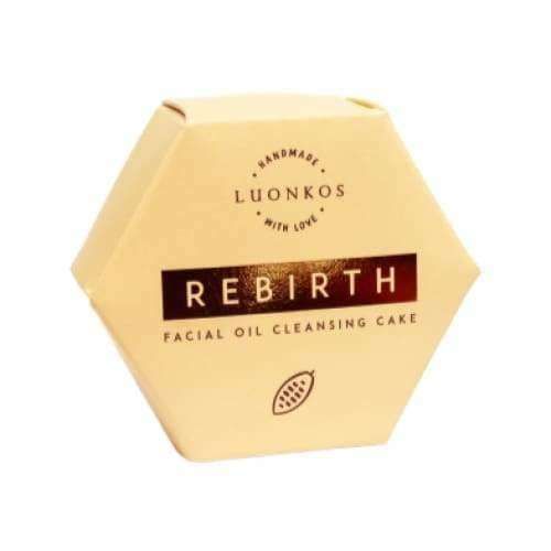 A beige hexagonal box labeled Luonkos Rebirth Oil Cleansing Cake, featuring a cocoa bean icon and "Handmade with love" above the Luonkos brand—an all-natural facial cleanser perfect for vegan skincare routines.
