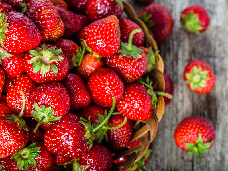 Erdbeeren in einem Korb auf einem Holztisch