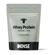 Ein grau-schwarzer Beutel mit DENSE Grass-Fed Whey Protein Vanilla (500 g), tierischen Ursprungs mit natürlichen Aromen und hoher Bioverfügbarkeit, zeigt ein Kuhsymbol auf der Verpackung und enthält Proteinpulver mit Vanillegeschmack.