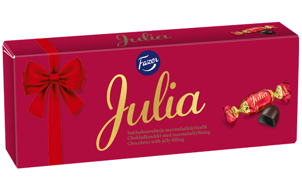 Eine rechteckige rote Schachtel Fazer Julia Chocolate Praline von Fazer mit roter Schleife, großer goldener Schrift "Julia" und Abbildungen einer verpackten Schokolade und einer mit Geleefüllung.