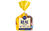 Ein Laib Fazer Real Rye von Fazer in gelber und durchsichtiger Verpackung zeigt dunkles, ballaststoffreiches Brot. Auf dem Etikett sind Weizengrafiken, finnischer Text und Symbole für 100 % Vollkorn und 10 % Ballaststoffgehalt abgebildet.
