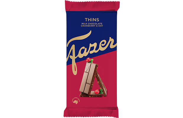 Fazer Thins Milchschokolade mit Preiselbeeren und Haferflocken hat eine blau-rote, diagonale Verpackung mit goldener Schrift, auf der gestapelte Schokoladenstücke, Preiselbeeren und Hafer zu sehen sind - ein echter finnischer Schokoladengenuss. Mindestens haltbar bis 12.11.2025.