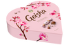 Die Fazer Geisha Gift Box ist eine herzförmige, rosafarbene Schachtel mit finnischer Schokolade, verziert mit Kirschblüten, dem Geisha-Logo und Bildern von Milchschokolade mit Haselnussfüllung von Fazer.