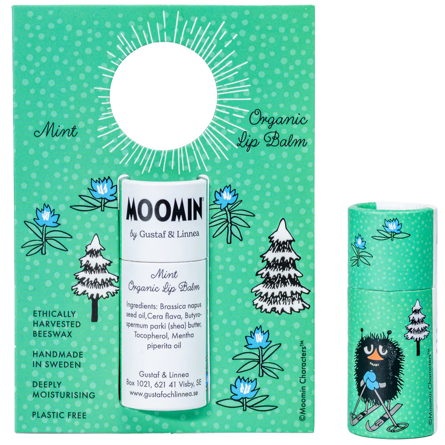 Auf der grünen Verpackung und der Tube von Gustaf & Linnea Mumin Lipbalm Stinki sind Bäume, Blumen und eine Mumin-Figur abgebildet. Der Lippenbalsam wird in Schweden hergestellt, stammt aus ethischen Quellen und enthält natürliche Inhaltsstoffe wie Bio-Minze und Bienenwachs.