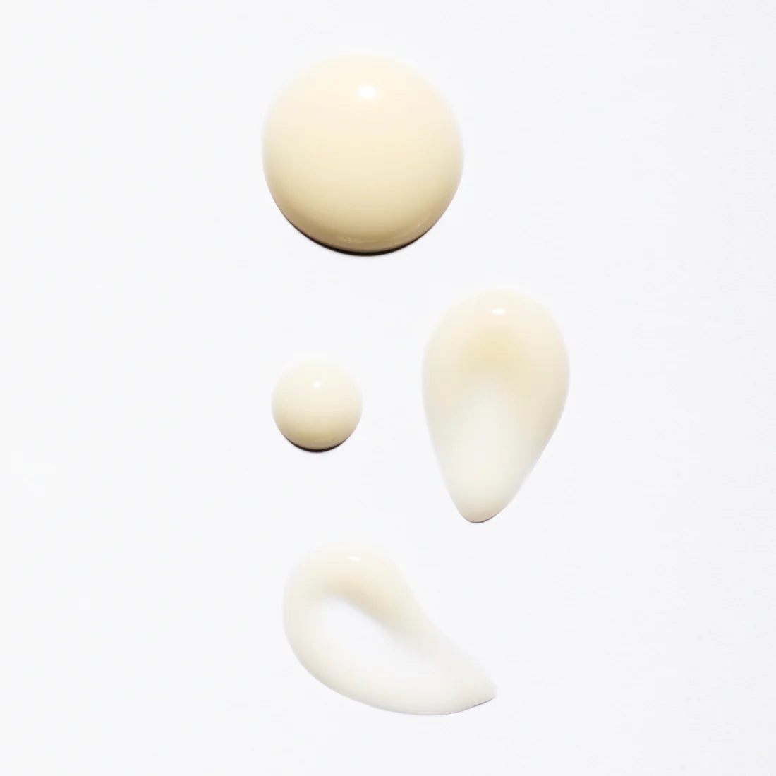 Vier Tropfen des Lumene Nordic-C Glow Renew Night Serum, einer cremig-beigen Formel mit arktischer Moltebeere und Vitamin C, sind auf weißem Hintergrund in verschiedenen runden und tropfenförmigen Formen abgebildet.