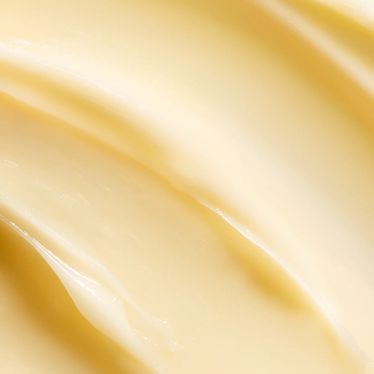 Nahaufnahme der cremigen, geschmeidigen, hellgelben Lumene Nordic-C Strength & Shine 2-in-1 Haarmaske von Lumene, die eine weiche, wellige Textur aufweist und mit Vitamin C angereichert ist.