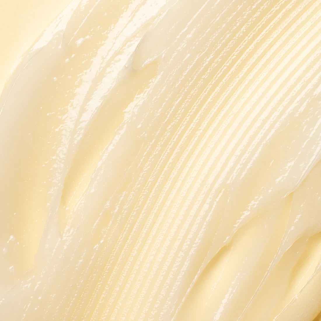 Nahaufnahme von Lumene Nordic-C Strength & Shine Conditioner von Lumene - ein cremiger, hellgelber Conditioner mit glatter, glänzender Textur und sichtbaren Rillen, der auf einer flachen Oberfläche verteilt wird.