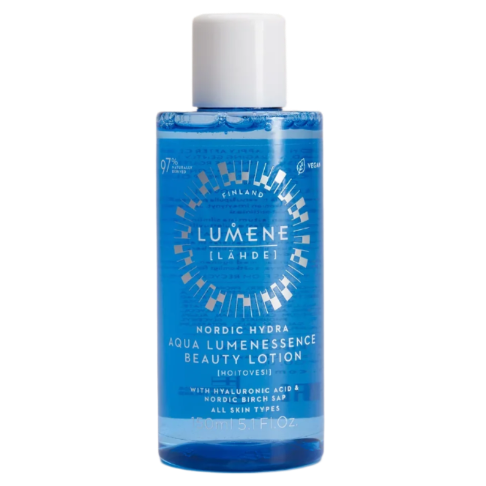 Die blaue Flasche der Lumene Nordic Hydra Aqua Lumenessence Beauty Lotion von Lumene mit weißem Verschluss hebt feuchtigkeitsspendende Inhaltsstoffe wie Hyaluronsäure und Birkensaft für eine strahlende Haut hervor. Für alle Hauttypen geeignet.