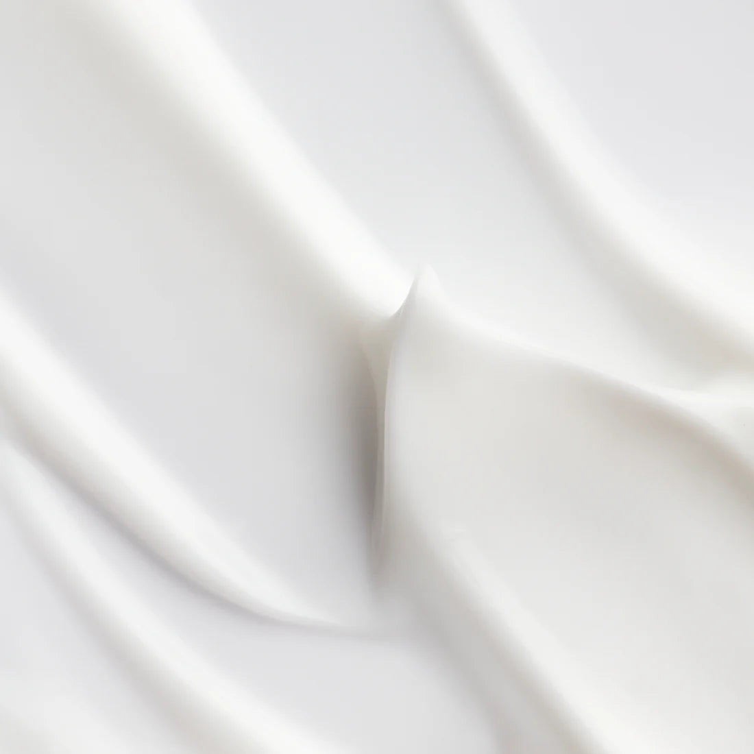 Glatter weißer Stoff mit sanften, fließenden Falten und weichen Schattierungen erinnert an die elegante, seidige Textur und die tiefgreifende Feuchtigkeitszufuhr der Lumene Nordic Hydra Hydration Recharge Overnight Cream von Lumene.