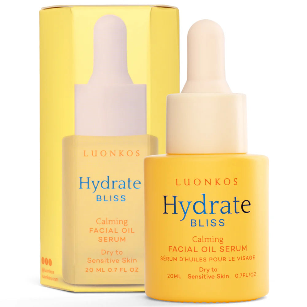 Eine gelbe Flasche Luonkos Bliss Facial Oil Serum mit einer Pipette, geeignet für trockene bis empfindliche Haut. Dieses parfümfreie Serum von Luonkos steht vor seiner passenden gelben Verpackung.